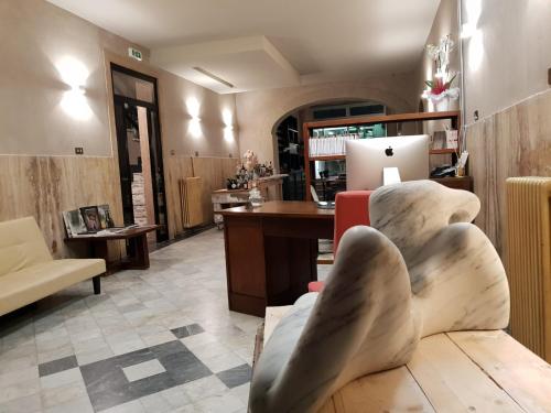 Art Hotel Pietrasanta في بيتراسانتا: غرفة معيشة مع أريكة ومكتب