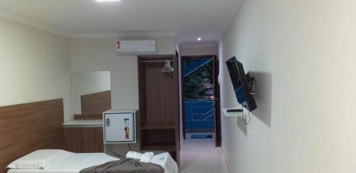 a hospital room with a bed and a tv at Pousada Morada Azul in Porto De Galinhas