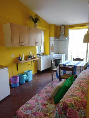 a kitchen with yellow walls and a table in a room at Appartamento Margherita in Montale