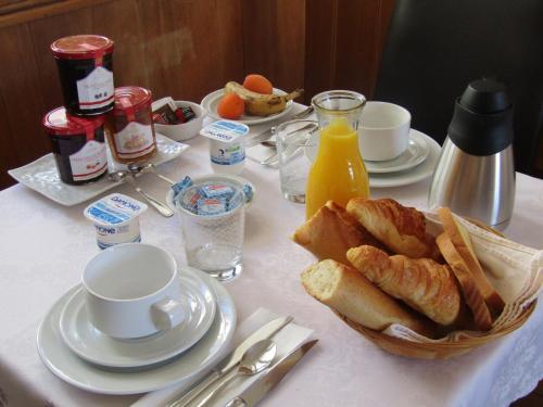 a table with a breakfast of bread and orange juice at Fifi Moulin in Serres