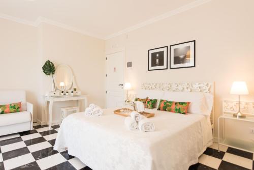een slaapkamer met een wit bed en een geruite vloer bij Residenza Il Sole in Monopoli