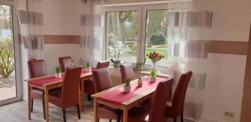 a dining room with a table and chairs and a window at Gästehaus Strudthoff in Ganderkesee