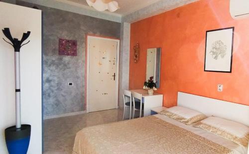 1 dormitorio con paredes de color naranja y 1 cama. en Capitan Shonny, en Portoscuso