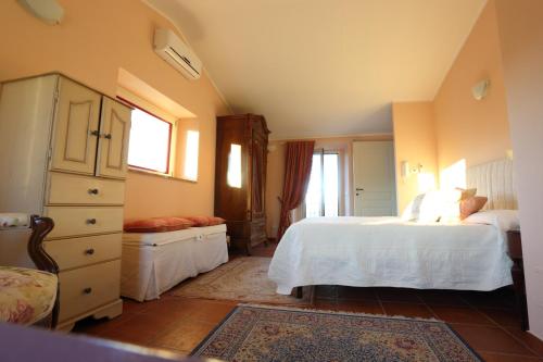 Un dormitorio con una cama blanca y una cómoda. en Casa Amarosa, en San Michele in Teverina