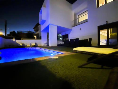 a swimming pool in front of a house at night at VILLA TAZA DE PLATA A in Huétor Vega