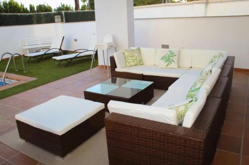 a patio with two couches and a table and chairs at VILLA TAZA DE PLATA A in Huétor Vega
