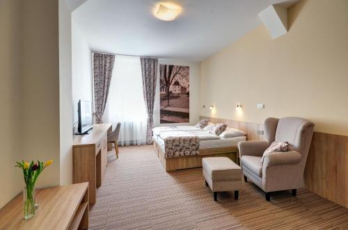 a hotel room with two beds and a chair at Hotel GTC 3* superior in Bílovec