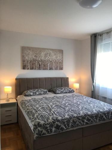 a bedroom with a bed and a painting on the wall at Luna Apartments, apartments with style in Zagreb