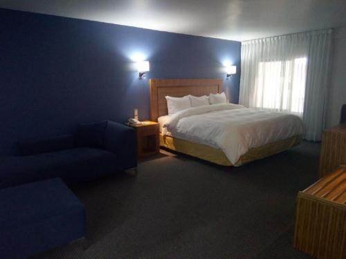 a hotel room with a bed and a chair at Radisson Hotel & Convention Center Toluca in Toluca