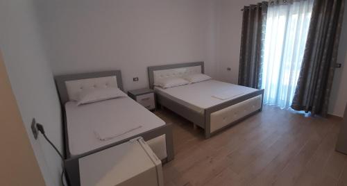 ein Zimmer mit zwei Betten und einem Fenster in der Unterkunft South Coast Villa in Borsh