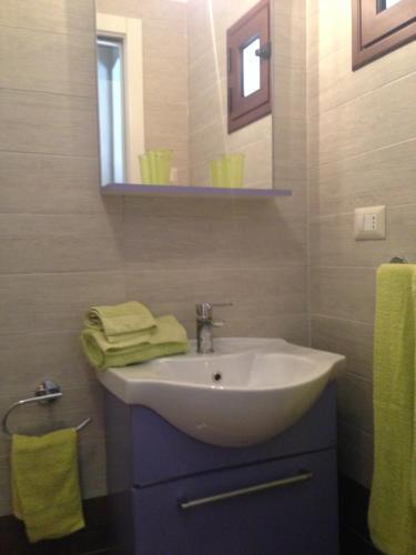 bagno con lavandino bianco e specchio di victoria’home a Margherita di Savoia