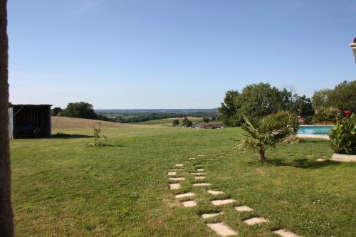 a stone path in a field with a tree at A POUTET in Labarthète