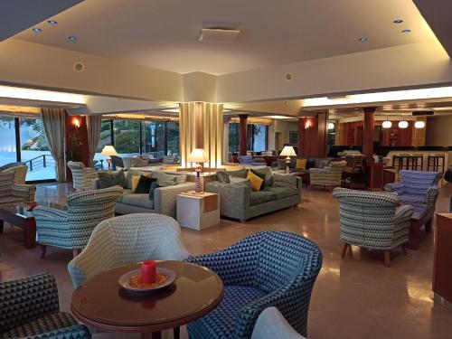 a lobby with couches and tables and chairs at King Minos Hotel in Tolo