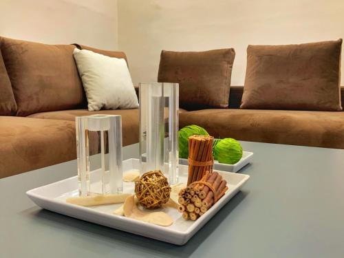 a table with a plate of food on a table with a couch at Petite Luxury Urban House in Tríkala