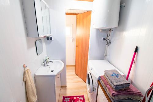 a bathroom with a sink and a washing machine at Kingsajz in Giżycko