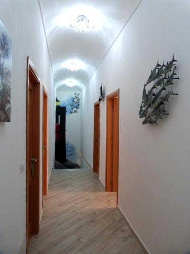 a hallway with white walls and wooden floors at Clelia's Boutique Rooms & Suites in La Maddalena