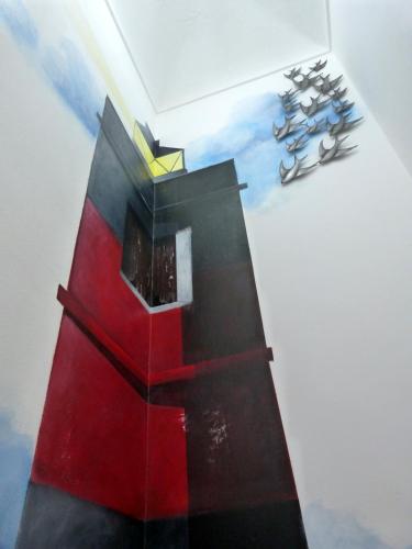 a painting of a lighthouse on a wall at Clelia's Boutique Rooms & Suites in La Maddalena