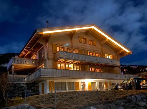 a house on top of a hill at night at Chalet Butterfly in Adelboden