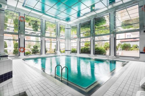duży kryty basen ze szklanym sufitem oraz duży pokój z oknami w obiekcie AL-DOM apartamenty Olymp 109 w Kołobrzegu