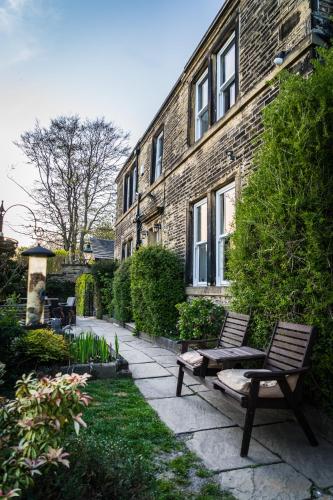 a bench sitting in front of a brick building at Shibden Hall View in Halifax