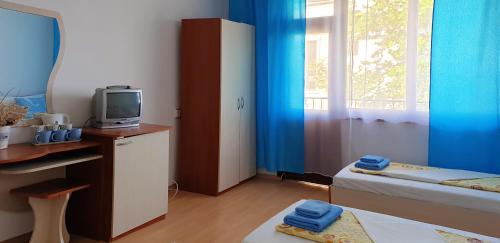 a small room with a bed and a television at Майстор Костадин - 1878 in Obzor