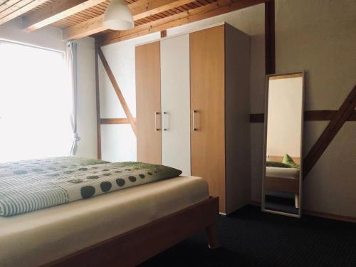 - une chambre avec un grand lit et un miroir dans l'établissement FeWo Stubenhocker, à Pleisweiler-Oberhofen