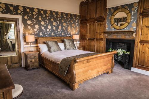 a bedroom with a large bed and a fireplace at Shibden Hall View in Halifax