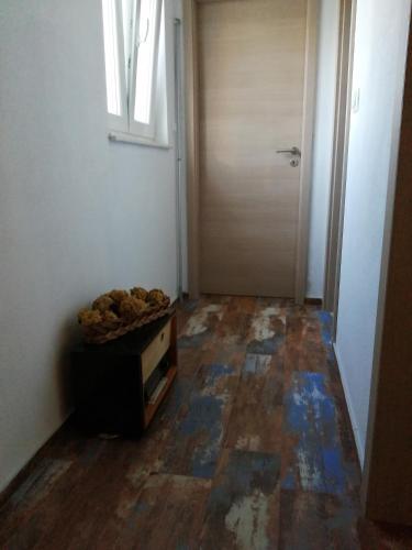 a hallway with a door and a table and a floor at Marcelovi dvori in Pirovac