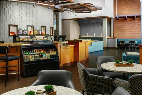 a restaurant with tables and chairs and a refrigerator at Hyatt Place Fort Lauderdale Airport/Cruise Port in Dania Beach
