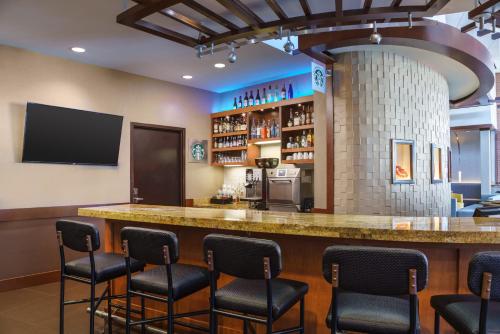 a bar in a restaurant with chairs around it at Hyatt Place Fort Lauderdale Airport/Cruise Port in Dania Beach