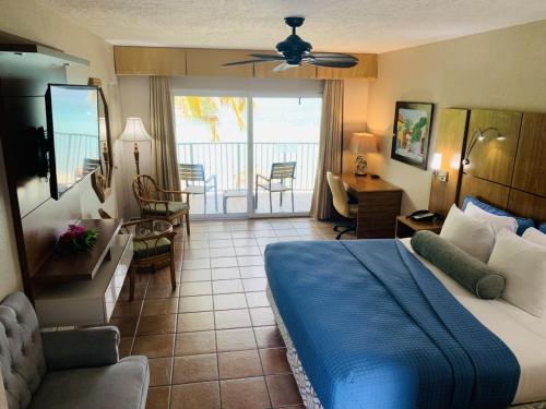 1 dormitorio con 1 cama y sala de estar con balcón. en Emerald Beach Resort en Lindbergh Bay