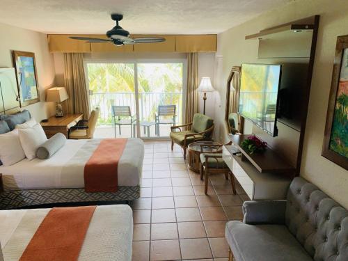 Lindbergh Bayにあるエメラルド ビーチ リゾートのベッド2台とリビングルームが備わるホテルルームです。