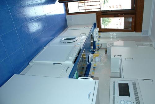 a kitchen with white cabinets and a blue wall at Apartamentos Costa Costa in Suances