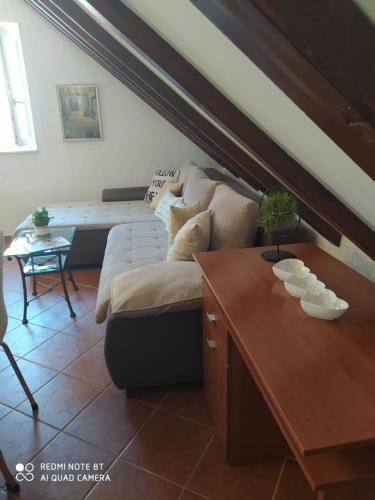 uma sala de estar com um sofá e uma mesa em Apartment Cetina em Omiš