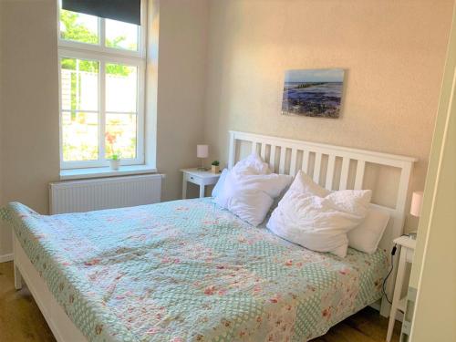 グロヴェにあるWohnung Luv - Alte Schuleのベッドルーム1室(白い枕付きのベッド1台、窓2つ付)