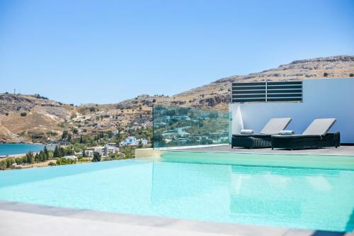 a villa with a swimming pool with mountains in the background at Blue Horizon in Lindos