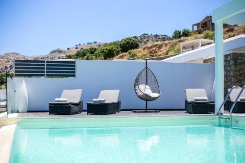a swimming pool with lounge chairs and a swimming pool at Blue Horizon in Lindos