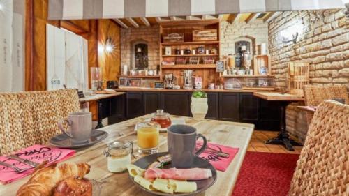 une table avec une assiette de pain et de jus d'orange dans l'établissement Les 5 rûches, à Courseulles-sur-Mer