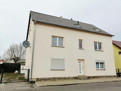 a white house with a black roof at Ferienwohnung im Spreewald "Vivien" in Vetschau