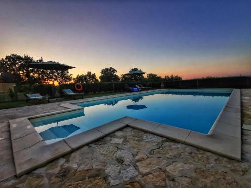 a swimming pool in a backyard with a sunset at Agriturismo I Casamenti in Istia dʼOmbrone