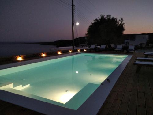 a swimming pool lit up at night at Kanala Studios in Kithnos