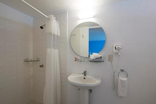 a white bathroom with a sink and a mirror at Villa Bejar Tequesquitengo in Tequesquitengo