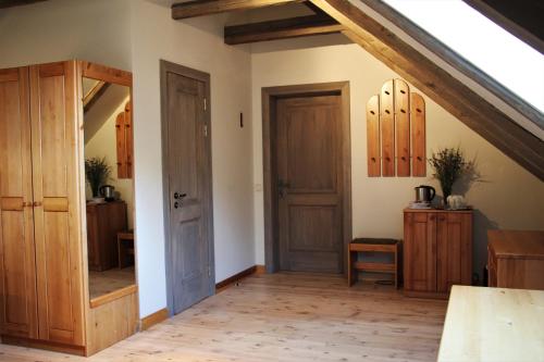 an attic room with wooden doors and wooden floors at Blankenfeldes muiža in Tērvete