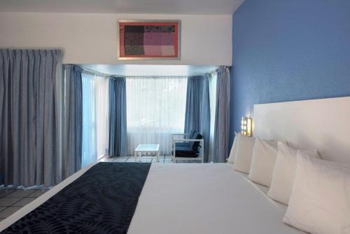 a hotel room with a large white bed and a window at Villa Bejar Tequesquitengo in Tequesquitengo