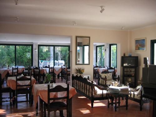 a dining room with tables and chairs and windows at Tara Beach Hotel in Skala Kefalonias