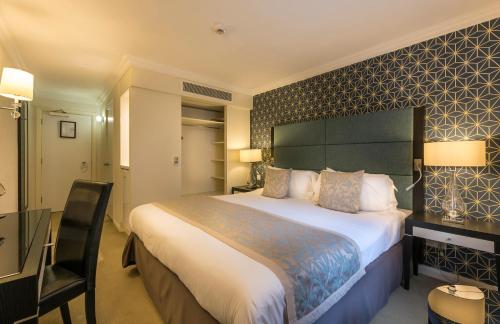a hotel room with a large bed and a desk at Number Four at Stow in Stow on the Wold