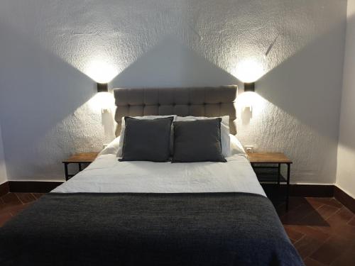 a bedroom with a bed with two pillows and two lamps at Hostal Cuzco in Trujillo