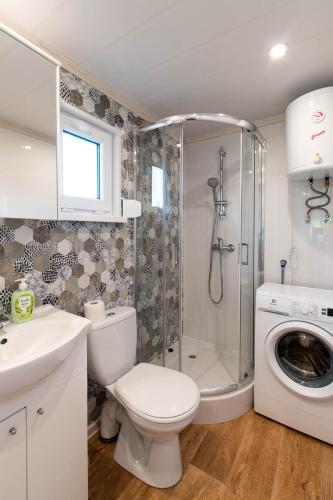 a bathroom with a toilet and a shower and a washing machine at Szuflandia in Giżycko