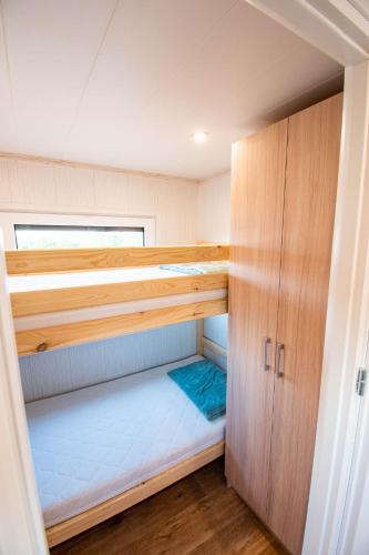 a small room with two bunk beds and wooden cabinets at Szuflandia in Giżycko