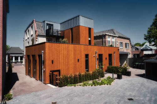 a brick building with a balcony on top of it at Dorpsherberg De Roskam in Nunspeet